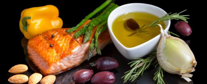 Elements of a Mediterranean diet. Salmon, almonts, dates, olive oil, peppers.