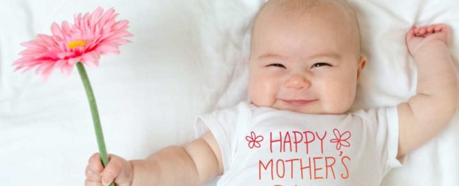 Mother's Day message with baby girl holding a flower