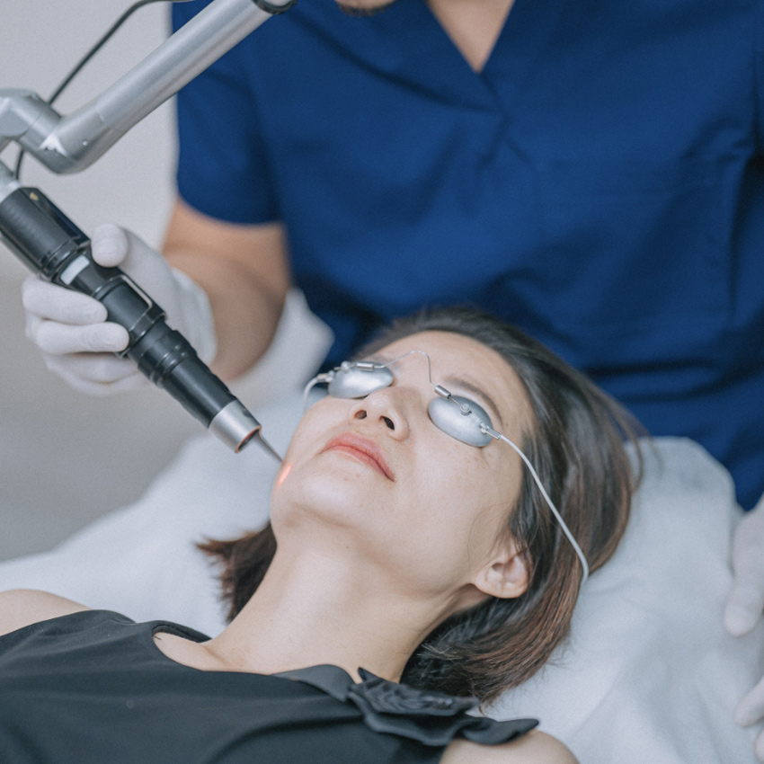 Person receiving a facial laser treatment while wearing protective eye shields.